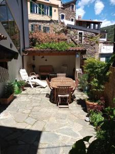 un patio con tavolo e sedie in un cortile di Holiday Home Carina a Dolceacqua