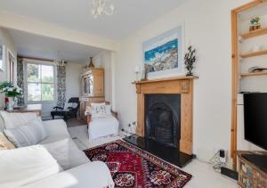 a living room with a white couch and a fireplace at Stargazy in Mousehole