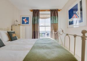 a bedroom with a bed and a large window at Stargazy in Mousehole