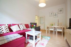 a living room with a pink couch and a table at Wohfühlen Garantiert Große Wohnung mit zwei Schlafzimmern und Terrasse in Görlitz