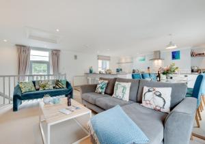 a living room with a couch and a kitchen at Pont View in Fowey