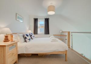 a bedroom with a bed and a desk and a window at Quayside in Porthleven