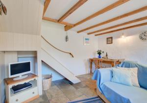 a living room with a couch and a tv at Renes Cottage in Ruan Minor