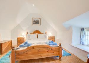 a bedroom with a wooden bed with blue towels on it at Renes Cottage in Ruan Minor