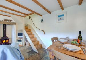 a dining room with a table and a staircase at Renes Cottage in Ruan Minor