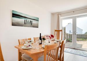 una sala da pranzo con tavolo, sedie e finestra di Sea Breezes a Porthleven