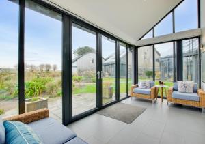 a living room with glass windows and a couch at St Cadoc in Padstow