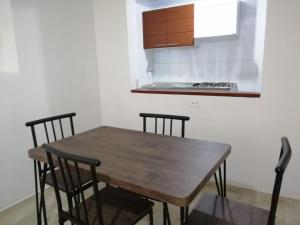 cocina con mesa de madera y sillas en Habitación Privada y Confortable cerca a Centro Mayor y al Centro Histórico, en Bogotá