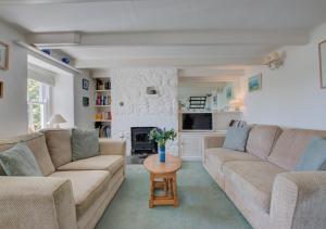 a living room with a couch and a table at Tamarisk in Mousehole