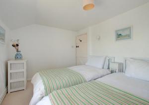 two beds in a bedroom with white walls at Tamarisk in Mousehole