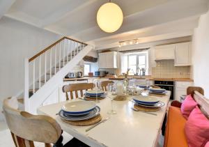 a kitchen with a table with chairs and a dining room at The Byre - Sennen in Sennen