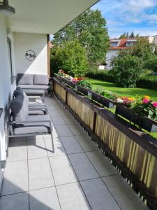 patio z krzesłami i kwiatami na balkonie w obiekcie Bergliebe - Talstation w mieście Blaichach