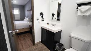 a small bathroom with a sink and a toilet at SeaSide Inn & Suites in Santa Cruz