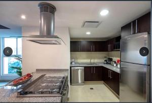 uma cozinha com um frigorífico de aço inoxidável e um fogão em Ocean front Grand Venetian corner condo em Puerto Vallarta