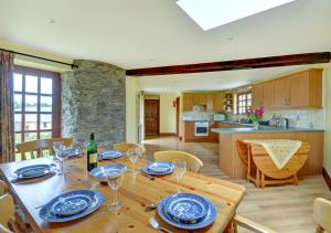 a dining room and kitchen with a wooden table with wine glasses at Trembleath Parlour in Saint Mawgan