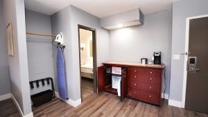 uma pequena sala com um quarto com uma cómoda em SeaSide Inn & Suites em Santa Cruz