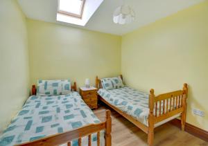 a bedroom with two beds and a window at Trembleath Parlour in Saint Mawgan