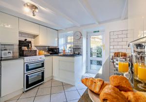 a kitchen with a plate of bread and orange juice at Victoria House - St Issey in Saint Issey