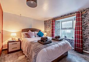 a bedroom with a bed and a brick wall at Victoria House - St Issey in Saint Issey