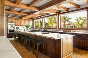a kitchen with a large island with bar stools at The Zenda Estate in Indio