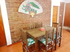 a dining room table with chairs and a brick wall at Complejo Hatun Yaya in Mendoza