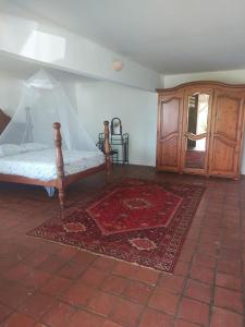 - une chambre avec un lit, un tapis et une armoire dans l'établissement Bois Canon, à Le Robert