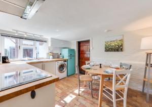 a kitchen and dining room with a table and chairs at Pike Cottage in Kettleburgh