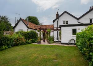 a white house with a yard in front of it at Pike Cottage in Kettleburgh