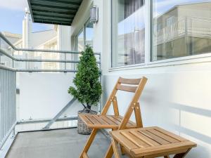 a wooden chair sitting on a porch with a plant at AKH81 in Akureyri
