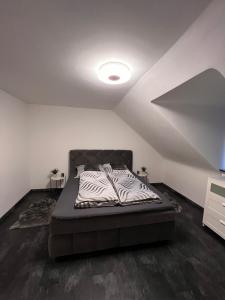 a bedroom with a bed with a black and white comforter at L1 Apartments in Neunkirchen