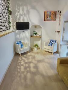 a living room with two chairs and a flat screen tv at Luxury Sea House in Rodi Garganico