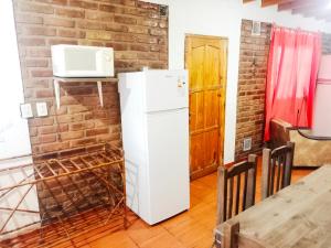 a kitchen with a white refrigerator and a microwave at Complejo Hatun Yaya in Mendoza