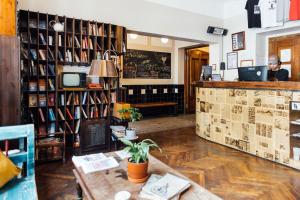 a coffee shop with a table in a room with books at Sir Toby's Hostel in Prague