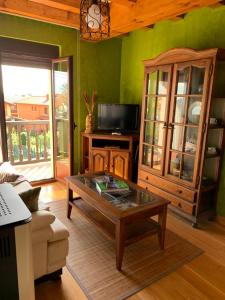 a living room with a coffee table and a tv at Alojamiento Turístico Prellezo in Prellezo