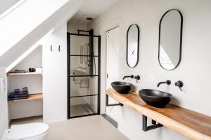 a bathroom with two sinks and two mirrors at Het Landzicht 