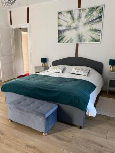 - une chambre avec un grand lit et une couverture verte dans l'établissement Domaine de Marchal - chambres et table d'hôtes, à Celles-sur-Durolle