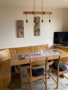 een eetkamer met een houten tafel en stoelen bij mountain house the deer in Tesero