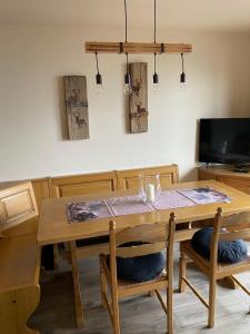 a dining room with a wooden table and chairs at mountain house the deer in Tesero