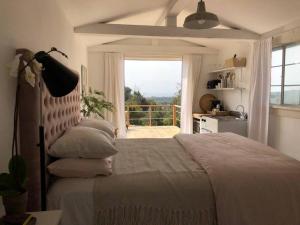 1 dormitorio con 1 cama y ventana grande en Cozy Malibu Getaway, Short Drive to Beach & Hike, en Malibú