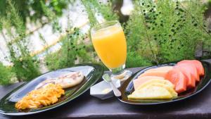 a table with two plates of food and a glass of orange juice at Hotel BLH 2 in Bucaramanga