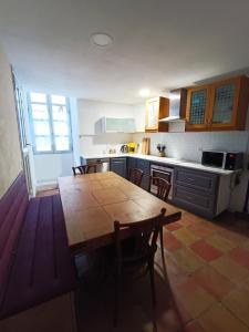 uma cozinha com uma mesa de madeira e cadeiras em La maison de la Traverse em Saint-Guilhem-le-Désert