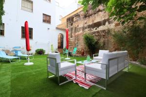 コルドバにあるcasa de los patios amuralladosの緑の芝生の上に白い椅子とテーブル