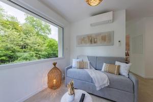 a living room with a couch and a large window at Le Rivera - Clim - Parking - Netflix - Nestor & Margot in Auterive