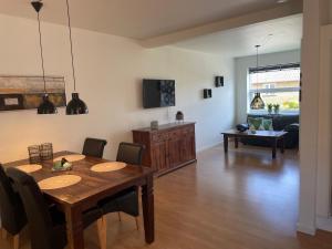 a dining room and living room with a table and chairs at Havne huset in Nakskov