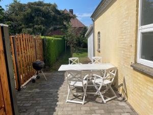 een patio met een tafel en stoelen en een grill bij Havne huset in Nakskov