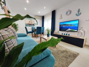 a living room with a blue couch and a tv at Apartments Lino in Selce