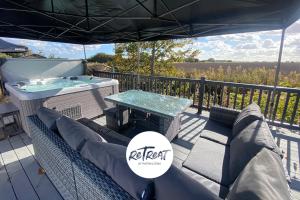 a deck with a hot tub and a table at ReTreat Breaks - 47 Park Lane in Patrington