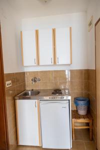 uma pequena cozinha com um lavatório e um fogão em Apartments Hodžić em Ulcinj
