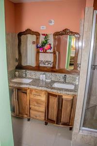 a bathroom with two sinks and two mirrors at The Hamilton's Nature Villa in Clarks Town