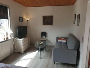 a living room with a couch and a tv at Cozy Apartment in Hirtshals in Hirtshals